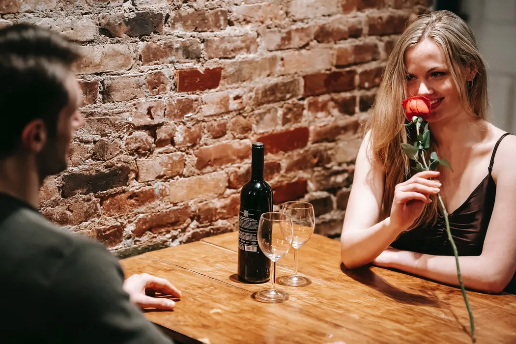 Ein Mann gibt einer Single Frau eine Rose beim Date